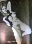 Girl smiles while lying nude, showcasing natural tits and pubic hair
